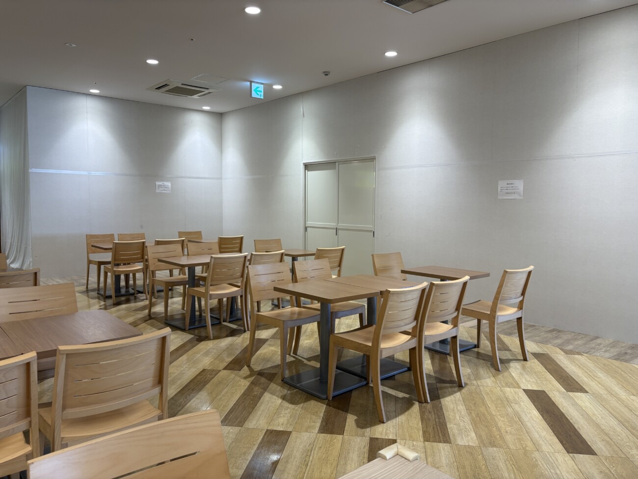 ニッケパークタウン2階フードコートの閉店した店舗区画 白い壁で囲われ、閉店のお知らせが貼られている