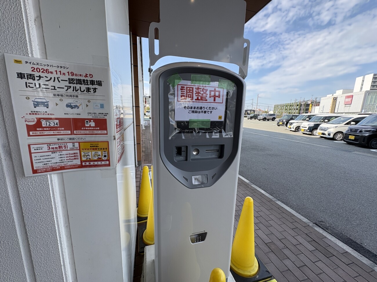 「調整中」の貼り紙がある事前精算機と「2026年11月19日（木）より車両ナンバー認識駐車場にリニューアルします」の告知